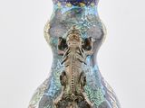 a vase with a dragon on it sitting on a table
