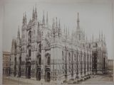 an old picture of a large building with a clock on it