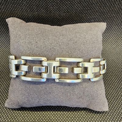 un gros plan d'un bracelet en argent posé sur un oreiller
