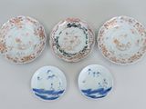 trois assiettes et deux bols décorés de motifs sur fond blanc
