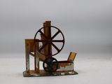une petite maquette de machine à filer posée sur une surface blanche