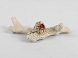 a close up of a gold ring with a ruby stone on it
