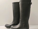 une paire de bottes de pluie noires posées sur une surface blanche