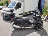 a scooter that is parked in front of a truck