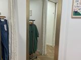 une chaise rose devant un miroir dans une pièce