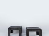 une paire de tables basses noires sur un fond blanc, avec une toile de fond blanche