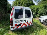 a white van parked next to a white car on the side of the road