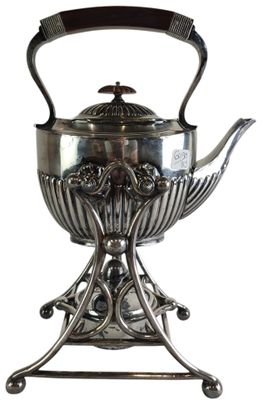 a silver tea pot on a stand with a handle