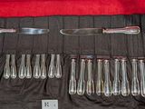 une photo d'un service d'argenterie posé sur une nappe noire