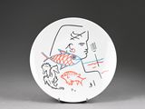 a white plate with a drawing of a woman and fish on it