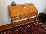 un petit bureau en bois sur lequel est posée une lampe