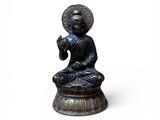 statue représentant une personne assise en position du lotus sur un fond blanc