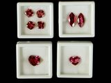 four square white trays with four different colored gems in them