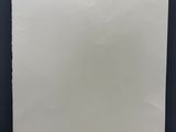 une feuille de papier blanche accrochée à un mur noir