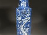a blue and white vase with a bird on it