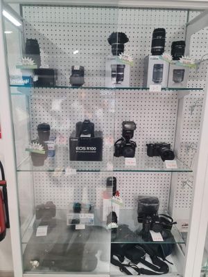 une vitrine en verre dans laquelle sont exposés de nombreux appareils photo différents