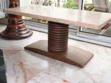 a marble table with a wooden base in the middle of a room