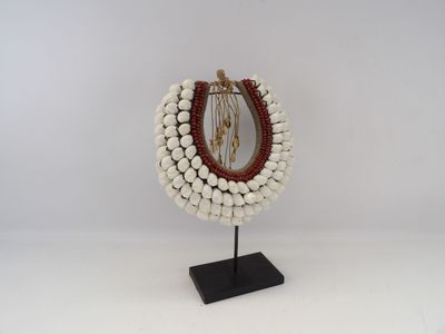a close up of a necklace on a stand with a mirror