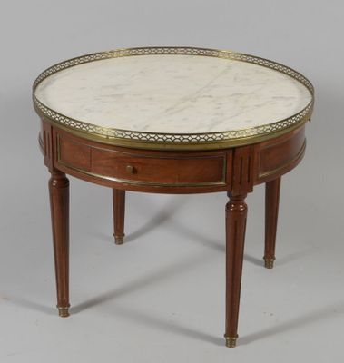 a round marble top coffee table with two drawers