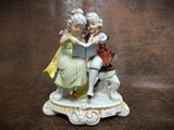 a figurine of a couple reading a book