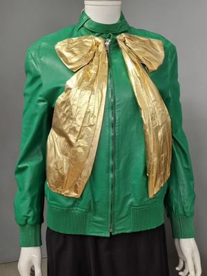 veste en cuir verte et dorée avec un nœud doré