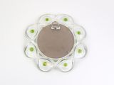 a picture of a round mirror with green flowers on it