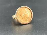 a close up of a gold coin ring with a face on it