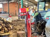 un camion garé à côté d'une pile de bois