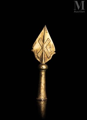 a close up of a gold object on a black surface