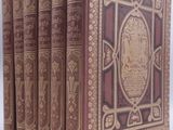 trois livres sont alignés sur une surface blanche