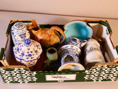 une boîte remplie de vases de différentes sortes posée sur une table