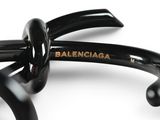 black glasses with balenciaga written on them on a white surface