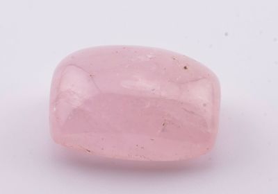 une pierre de quartz rose posée sur une surface blanche