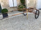 a wooden cart that is sitting in the gravel