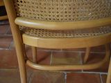 a close up of a wooden chair with a woven seat