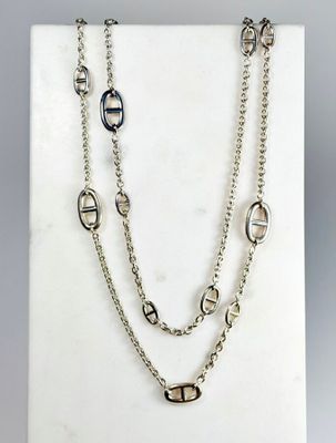 un gros plan d'un collier présenté sur une surface blanche