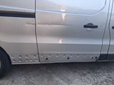 a silver van that has holes in the side of it
