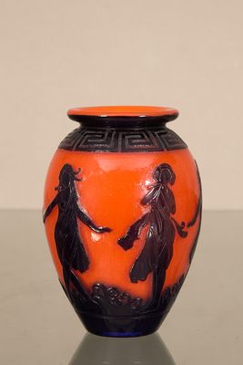un vase orange orné de motifs noirs, posé sur une table