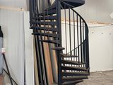 un escalier en colimaçon noir au milieu d'une pièce