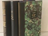 trois livres posés sur une table blanche