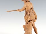 statue of a man holding a stick on top of a rock