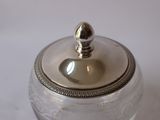 a glass jar with a silver lid sitting on a table