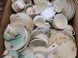 a box full of tea cups and saucers sitting on a table