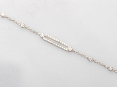 a close up of a silver bracelet with diamonds on a white background