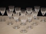 six wine glasses are lined up on a table with a black background