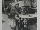 une vieille photo en noir et blanc d'un homme et d'une femme assis à une table
