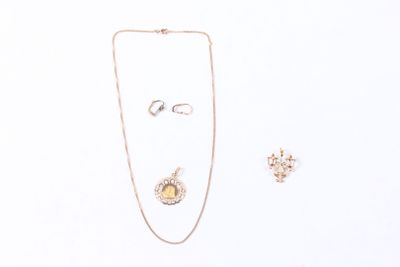 un collier, une boucle d'oreille et une bague posés sur une surface blanche