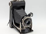 an old camera that is sitting on a white surface