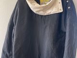 une photo d'une veste noire accrochée à un mur blanc