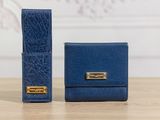 a pair of blue leather wallets sitting on top of a wooden table